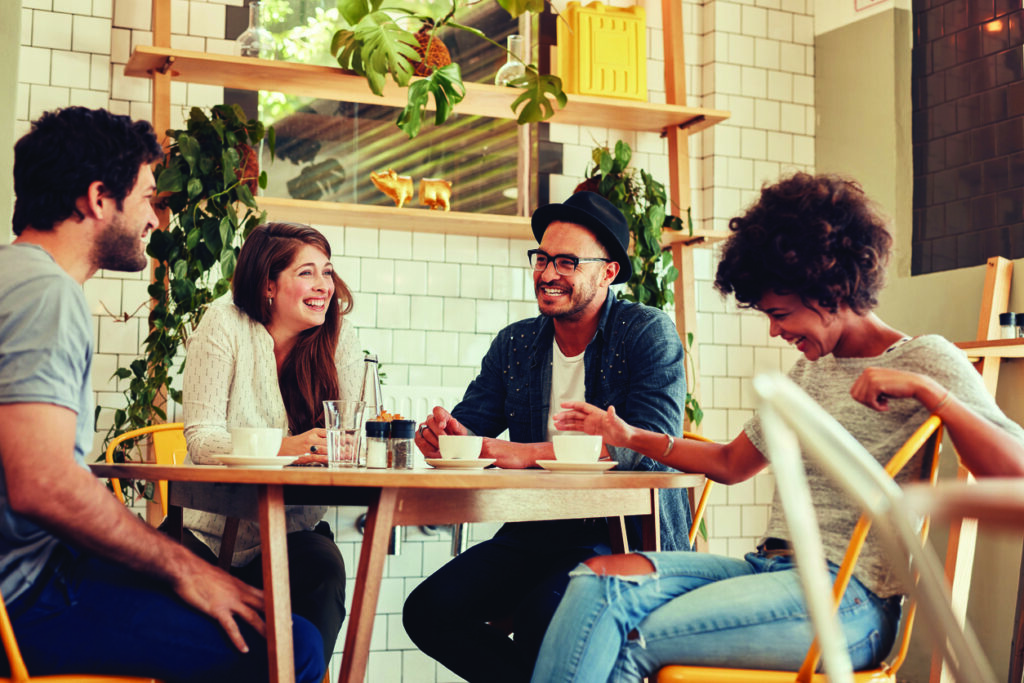 middle aged group of friends laughing at a cafe